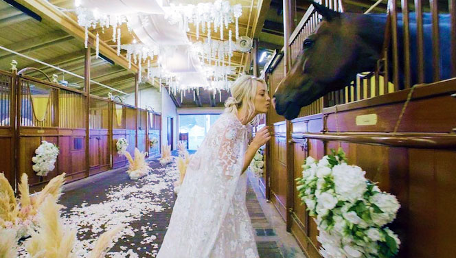 Kaley Cuoco vestida de novia besando a uno de los caballos