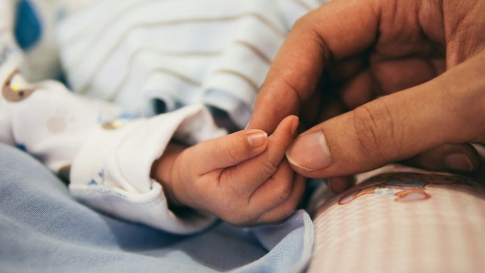 Madre sosteniendo la mano de su bebé