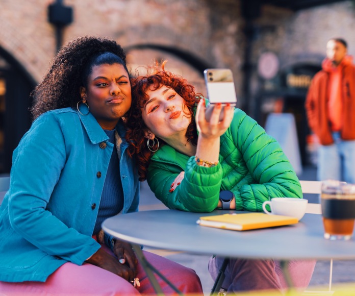 Amigas tomando fotografías al aire libre.