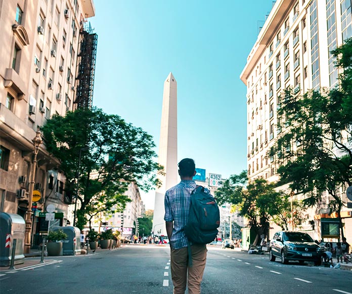 Hombre caminando por mitad de la carretera hacia el Obelisco de Buenos Aires