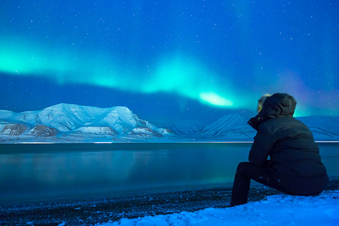 Hombre contemplando la Aurora Boreal