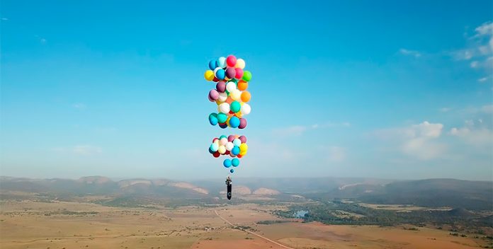 Un aventurero sobrevuela Sudáfrica suspendido en una silla con globos.