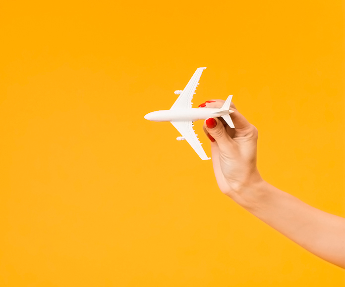 mano de mujer jugando con una avión de juguete