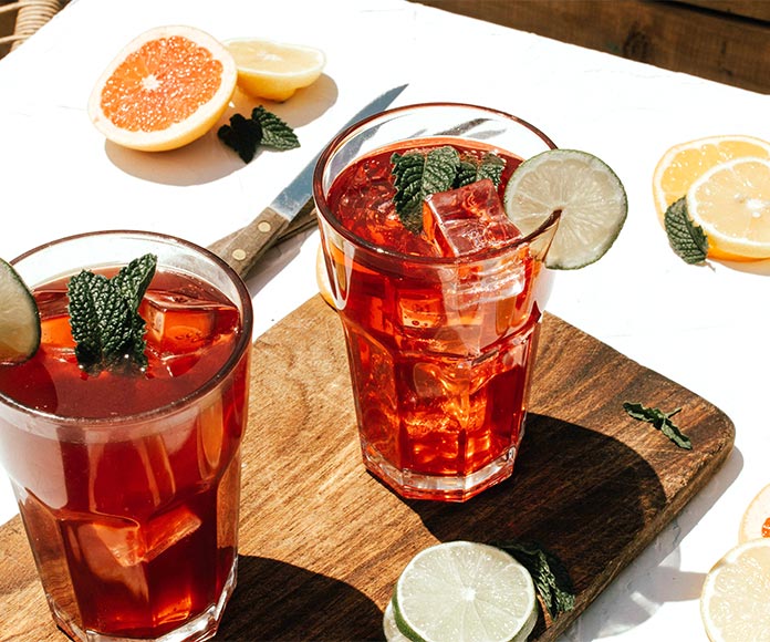 Dos bebidas de frutas con hielo sobre tabla de madera