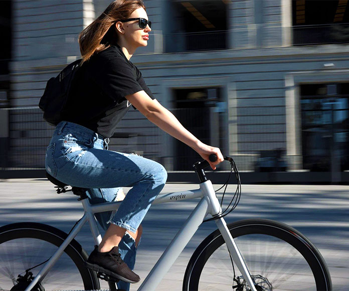 Chica en bicicleta por las calles de una ciudad