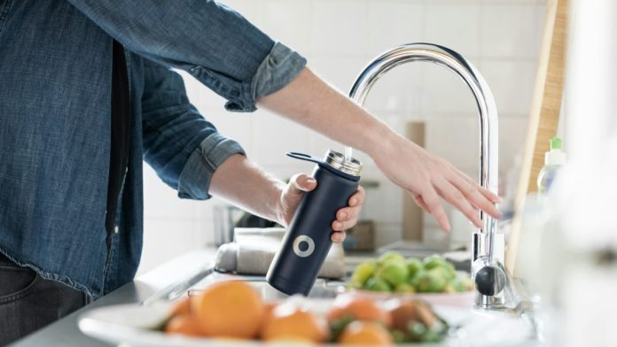 Persona llenando un termo con agua
