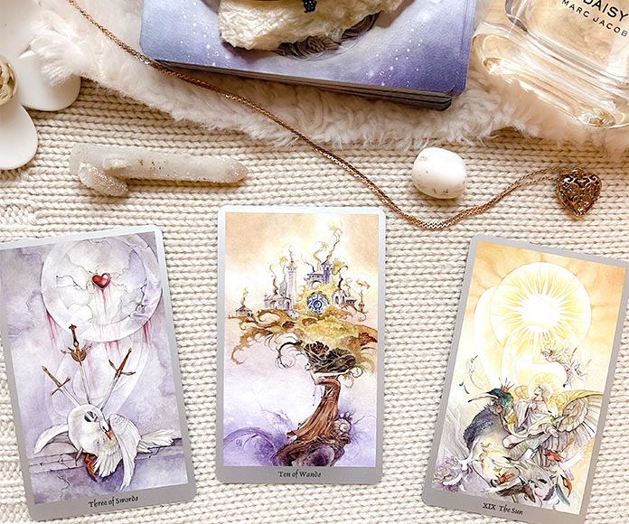 3 cartas del tarot junto a piedras energáticas