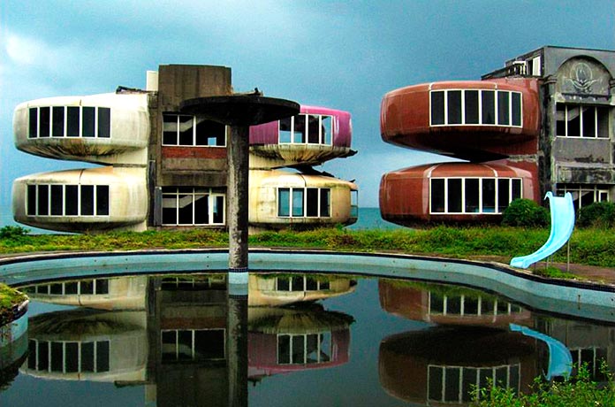 Piscina con tobogán tras los curiosos edificios