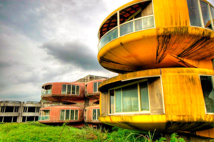 Casa OVNI amarilla frente a otra de color rosa