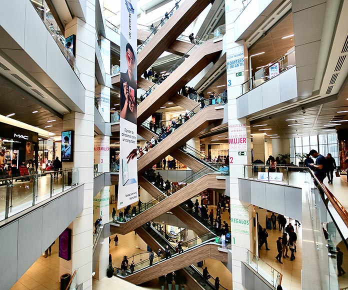 Interior de centro comercial con gente haciendo compras