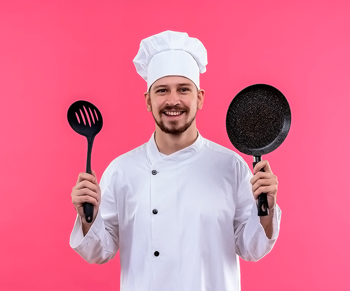 chef uniformado sosteniendo una espumadera y una sartén