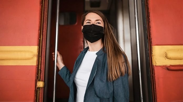 chica con mascarilla bajando de un autobús