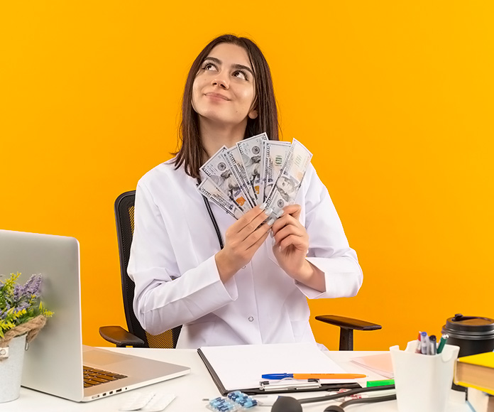 Chica feliz sentada en su escritorio con billetes en la mano