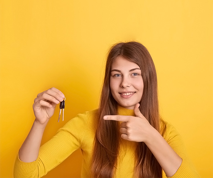 chica joven señalando un juego de llaves