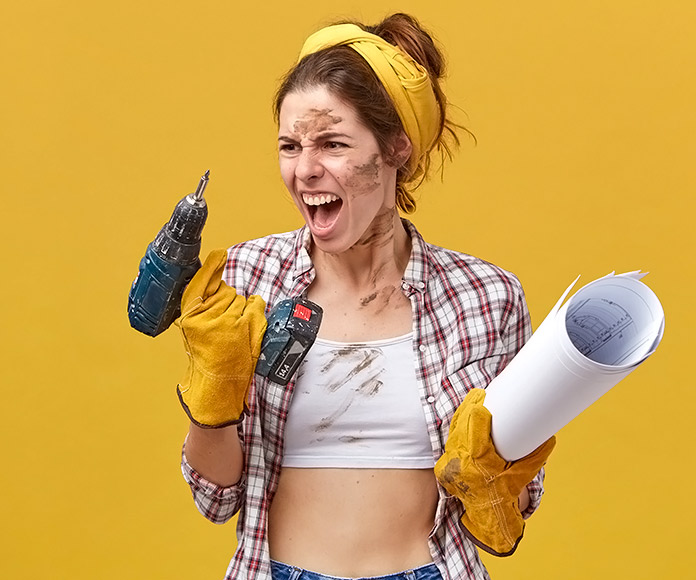 chica mirando sorprendida un taladro de batería