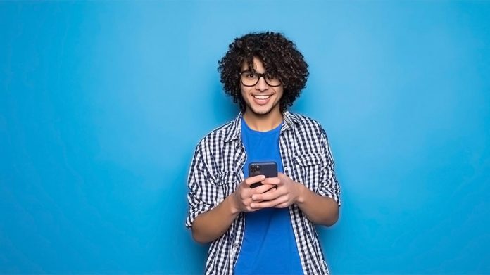 chico joven sujetando un teléfono móvil