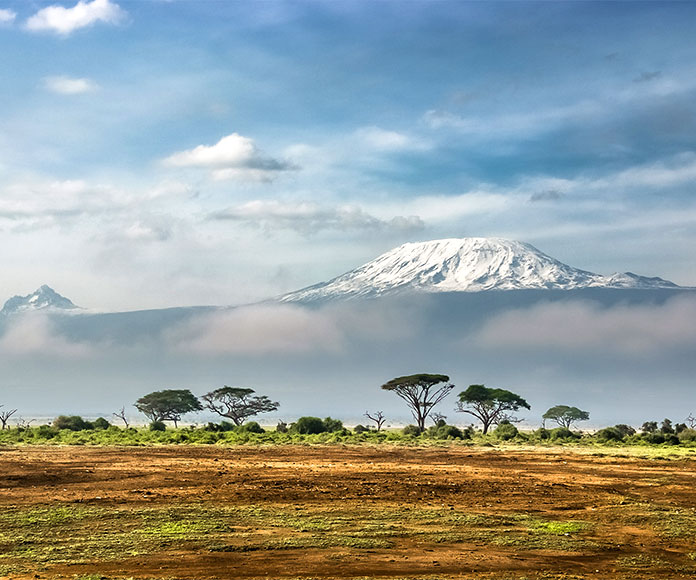 Paisaje de sabana arbolada con el Kilimanjaro al fondo desde el parque nacional de Amboseli