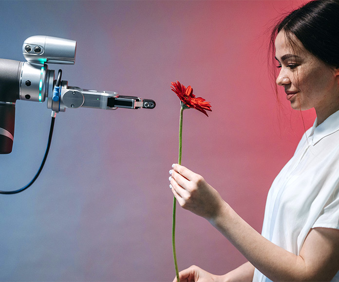 Mujer entregando una flor a un robot