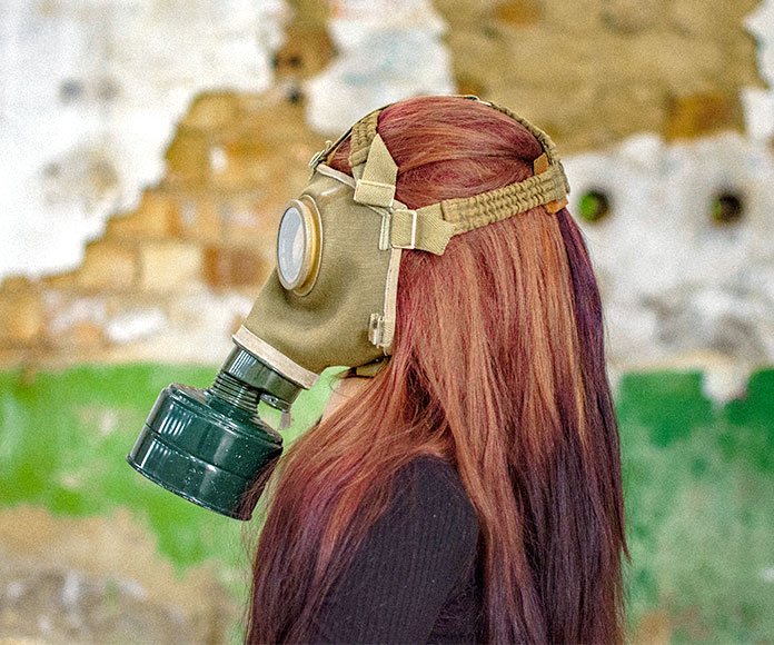 Mujer pelirroja con máscara de gas