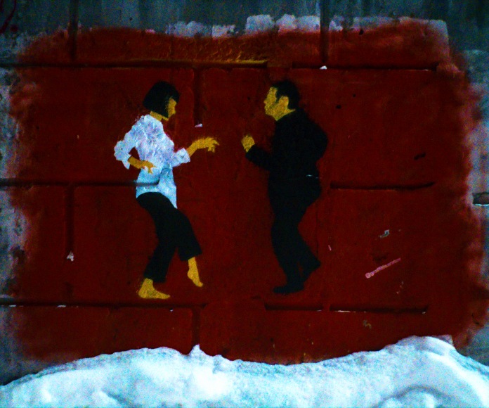 Graffiti de dos personas bailando.
