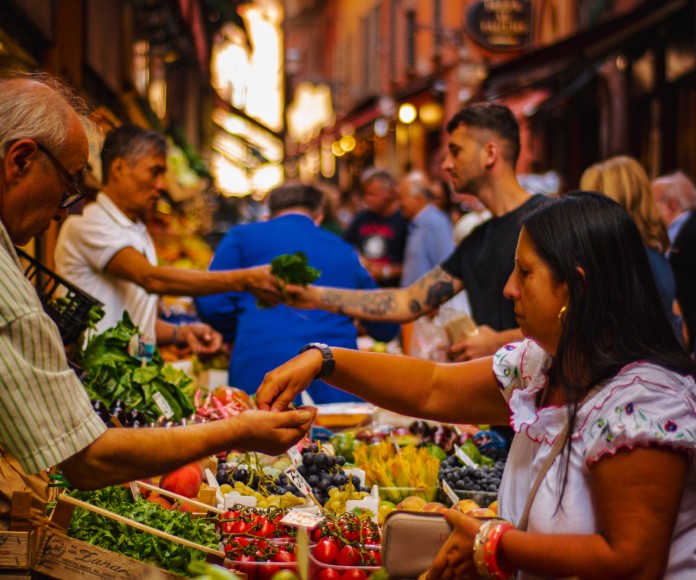 Personas comprando en un mercado a cielo abierto.