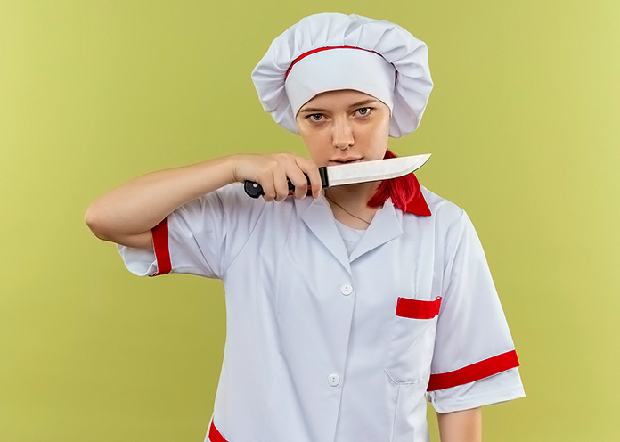 cocinera enseñando un cuchillo con cara de asesina