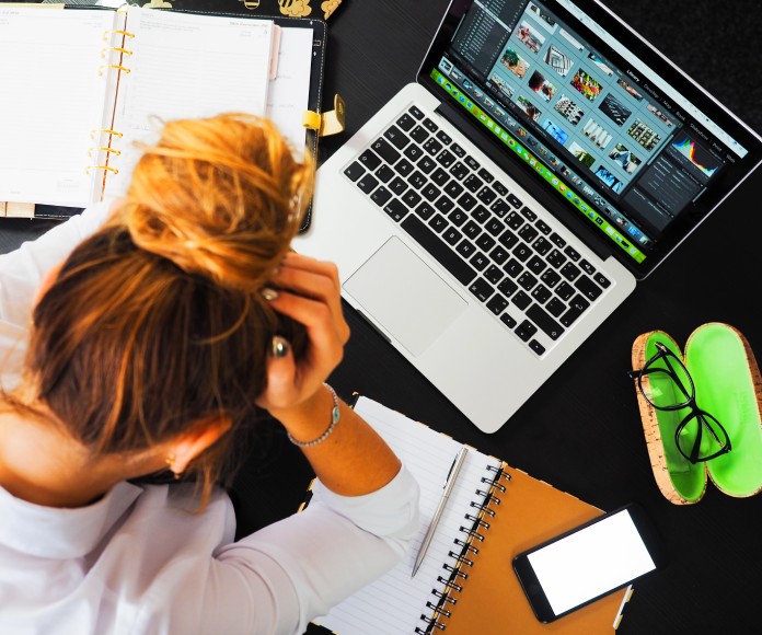 Mujer estresada frente a su laptop.