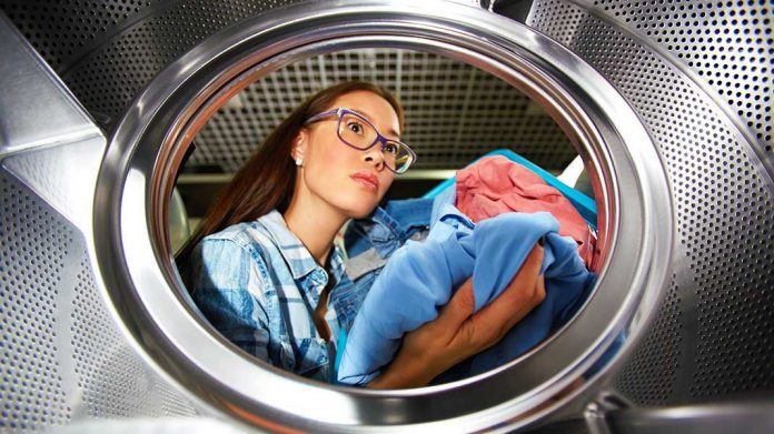 MIjer introduciendo ropa en una lavadora