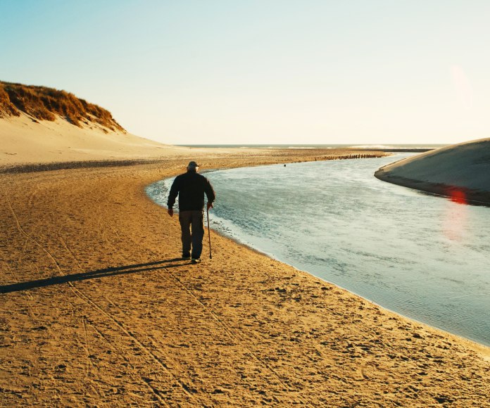Persona caminando en la orilla de la playa.