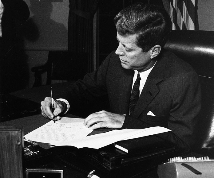 John Kennedy firmando un documento.