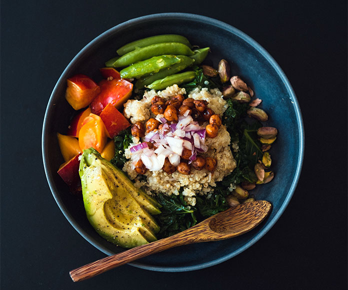 Cuenco con verduras, ensalada y cuchara de madera