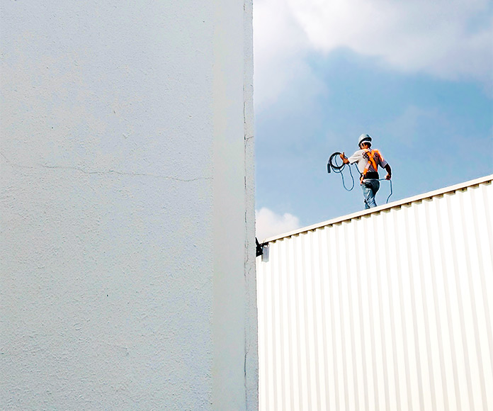 Trabajador de la construcción caminando sobre un tejado