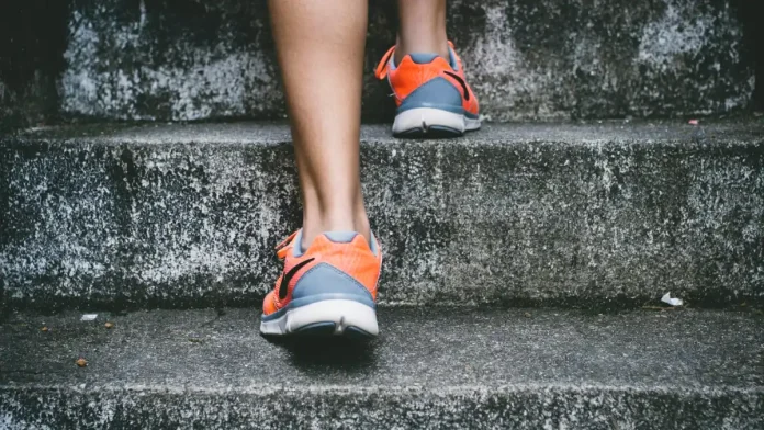 Pies con zapatillas de deporte subiendo unas escaleras