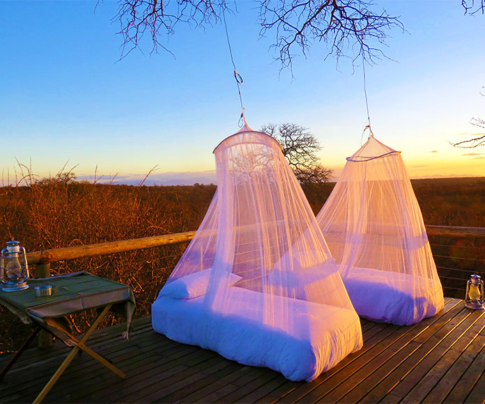 Dos camas en el exterior con mosquiteras