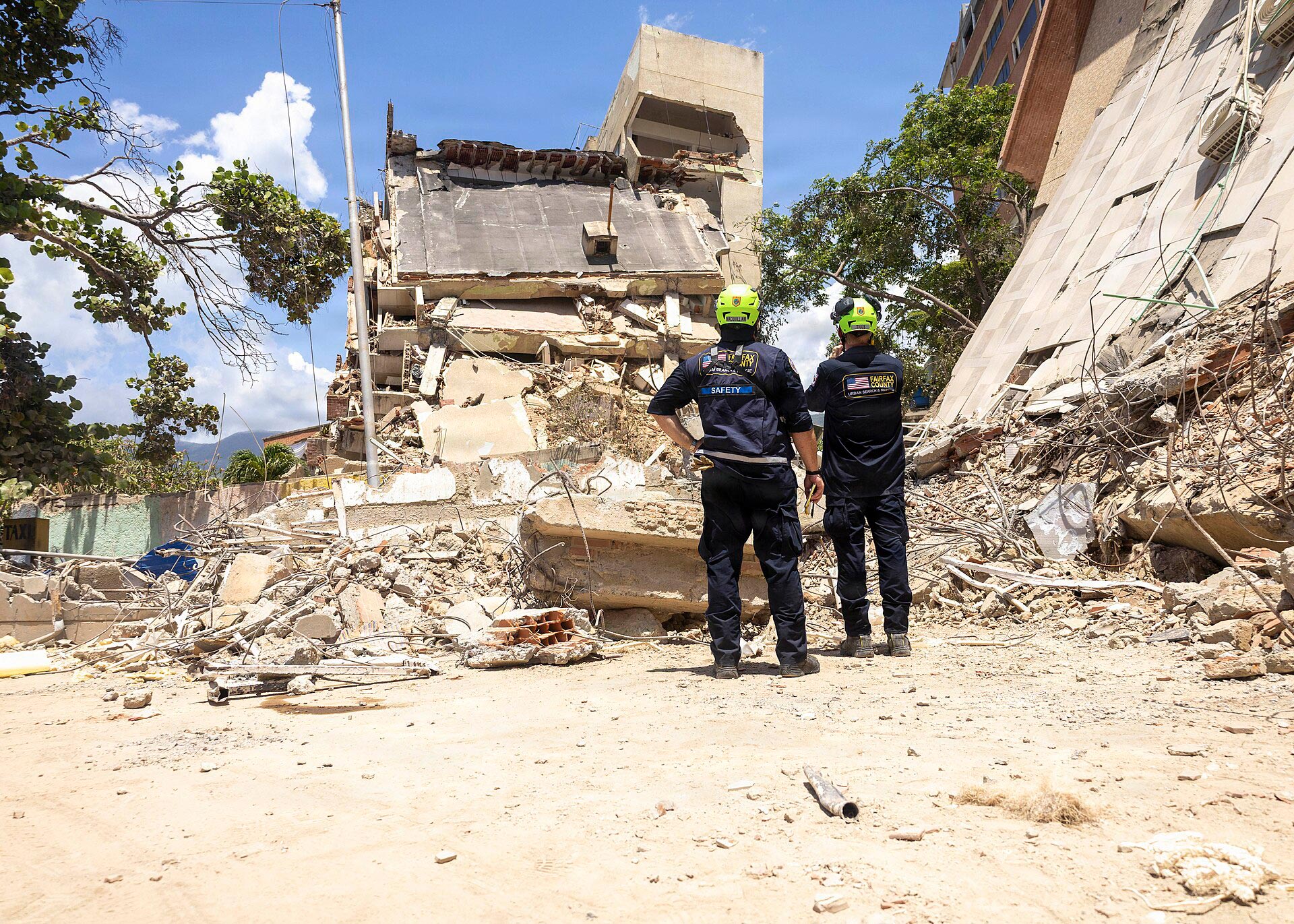 Miembros del equipo de búsqueda y rescate urbano inspeccionan una zona de desastre en La Guaira