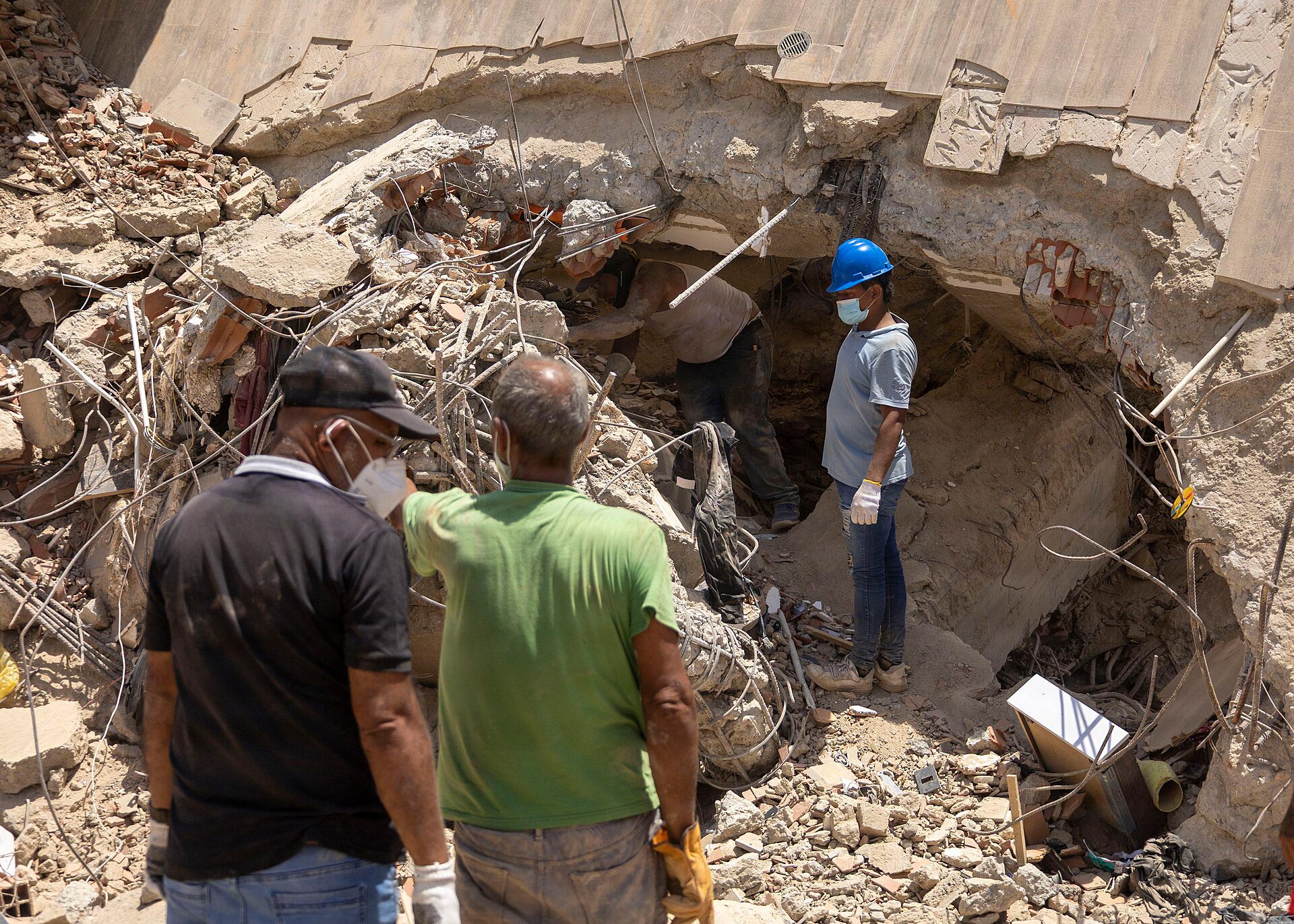 Ciudadanos venezolanos caminan entre los escombros de un edificio en La Guaira