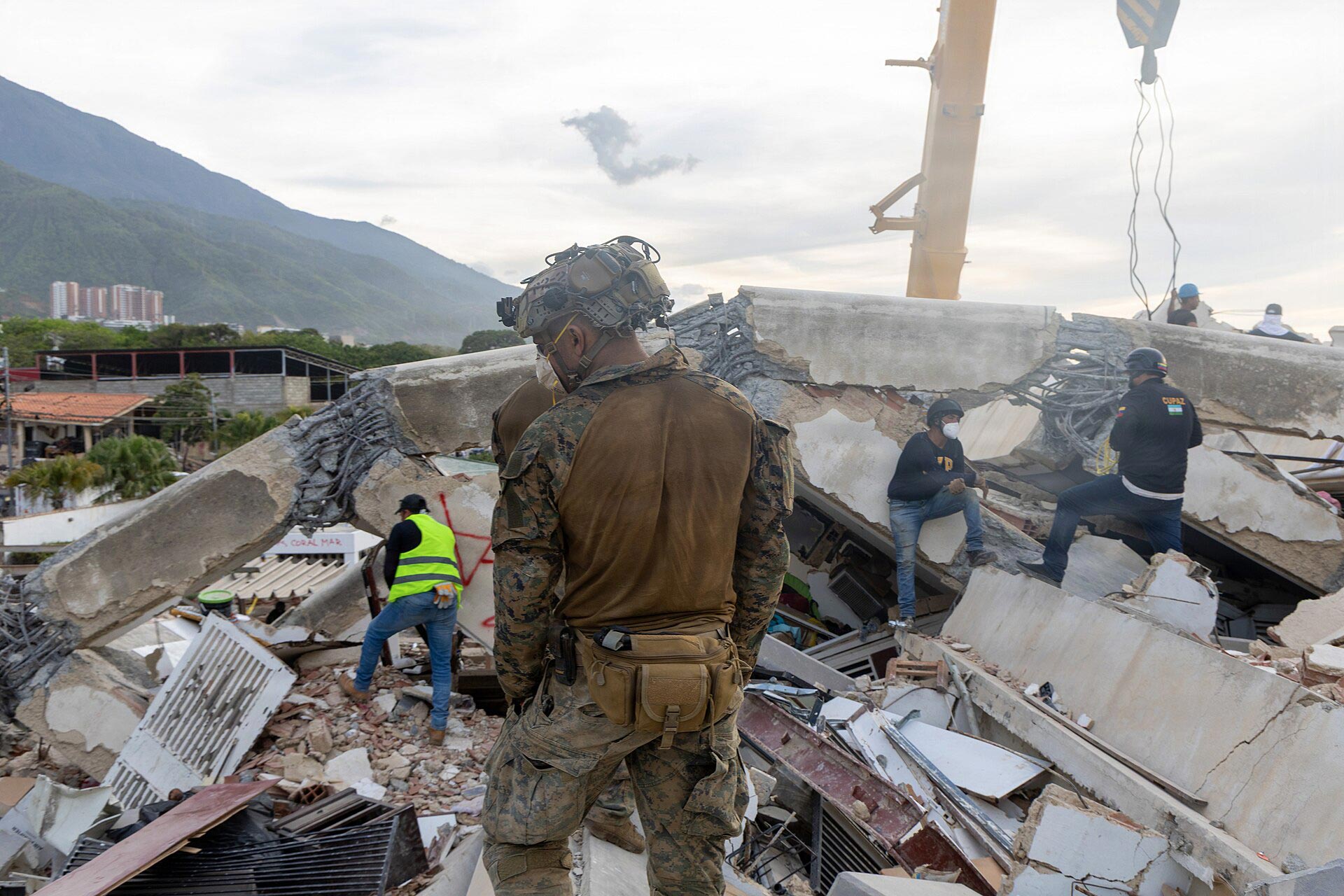 Varios civiles venezolanos y marines estadounidenses realizando labores de búsqueda y rescate en La Guaira