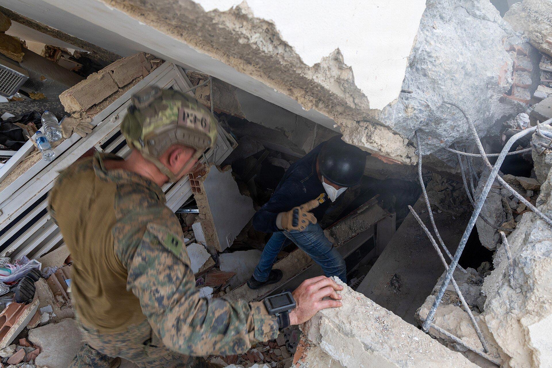 Un infante de marina estadounidense y un ciudadano local realizan una operación de búsqueda y rescate en La Guaira, Venezuela,