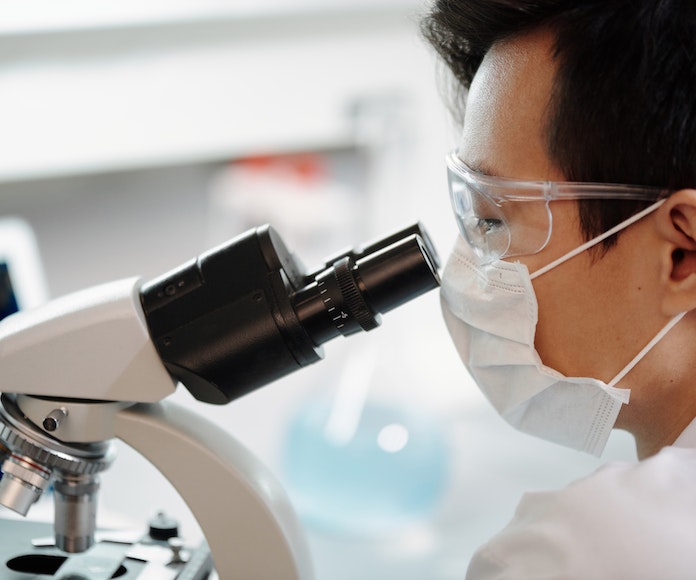 Doctor mirando por microscopio