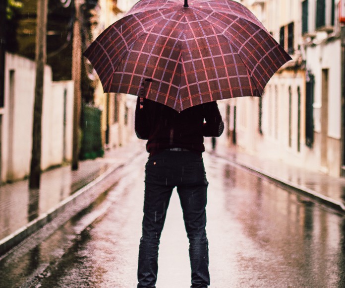 Hombre con un paraguas abierto bajo la lluvia.