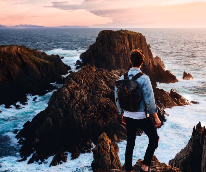 Hombre viendo un paisaje costero.