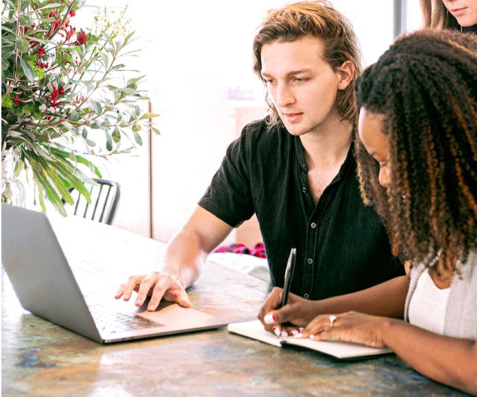 dos personas mirando el ordenador y escribiendo