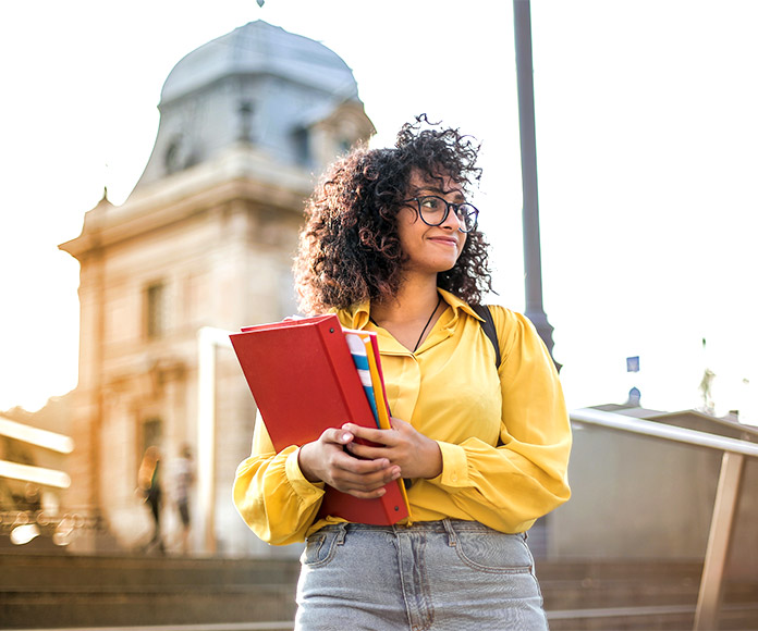 Estudiante con libros en un campus universitario