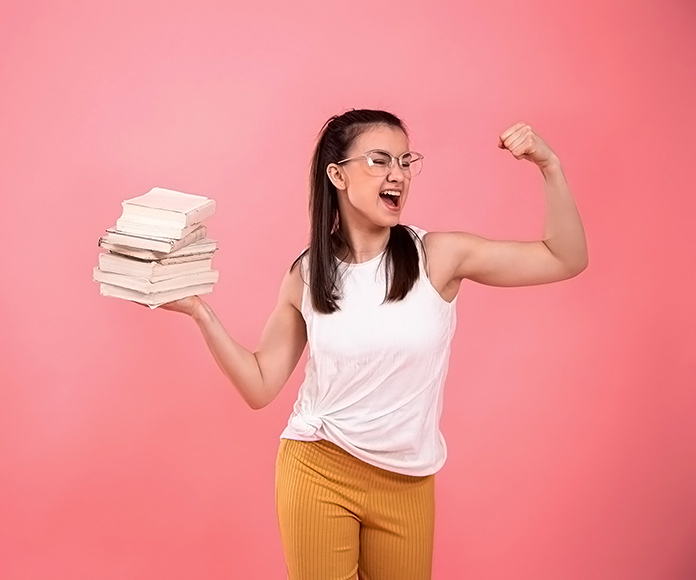 estudiante levantando una pila de libros con un brazo y marcando biceps con el otro