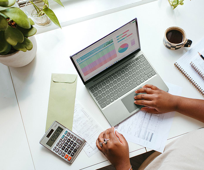 Persona trabajando en el ordenador con calculadora