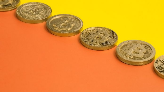 fila de bitcoins sobre fondo amarillo y naranja