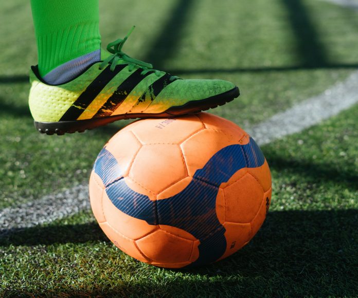 Pie pisando balón de fútbol