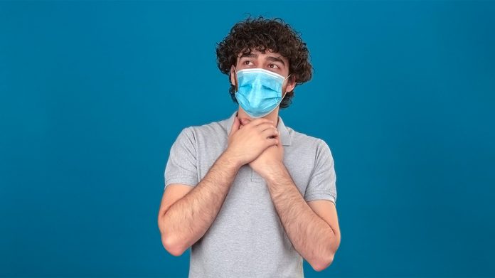 hombre con mascarilla tocándose la garganta con las dos manos