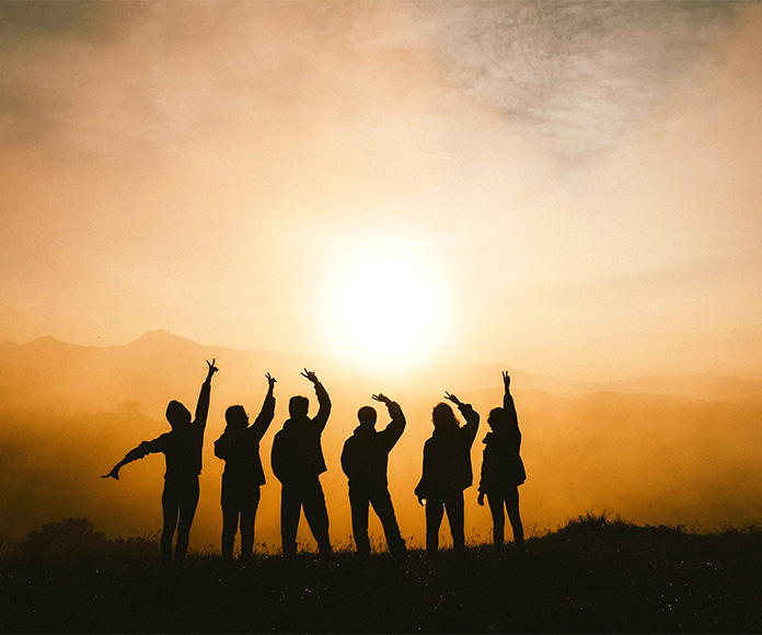 Silueta de un grupo de jóvenes en un paisaje natural