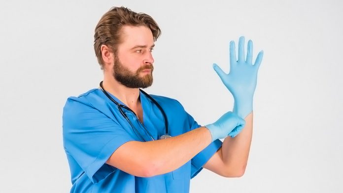 enfermero poniéndose unos guantes de vinilo